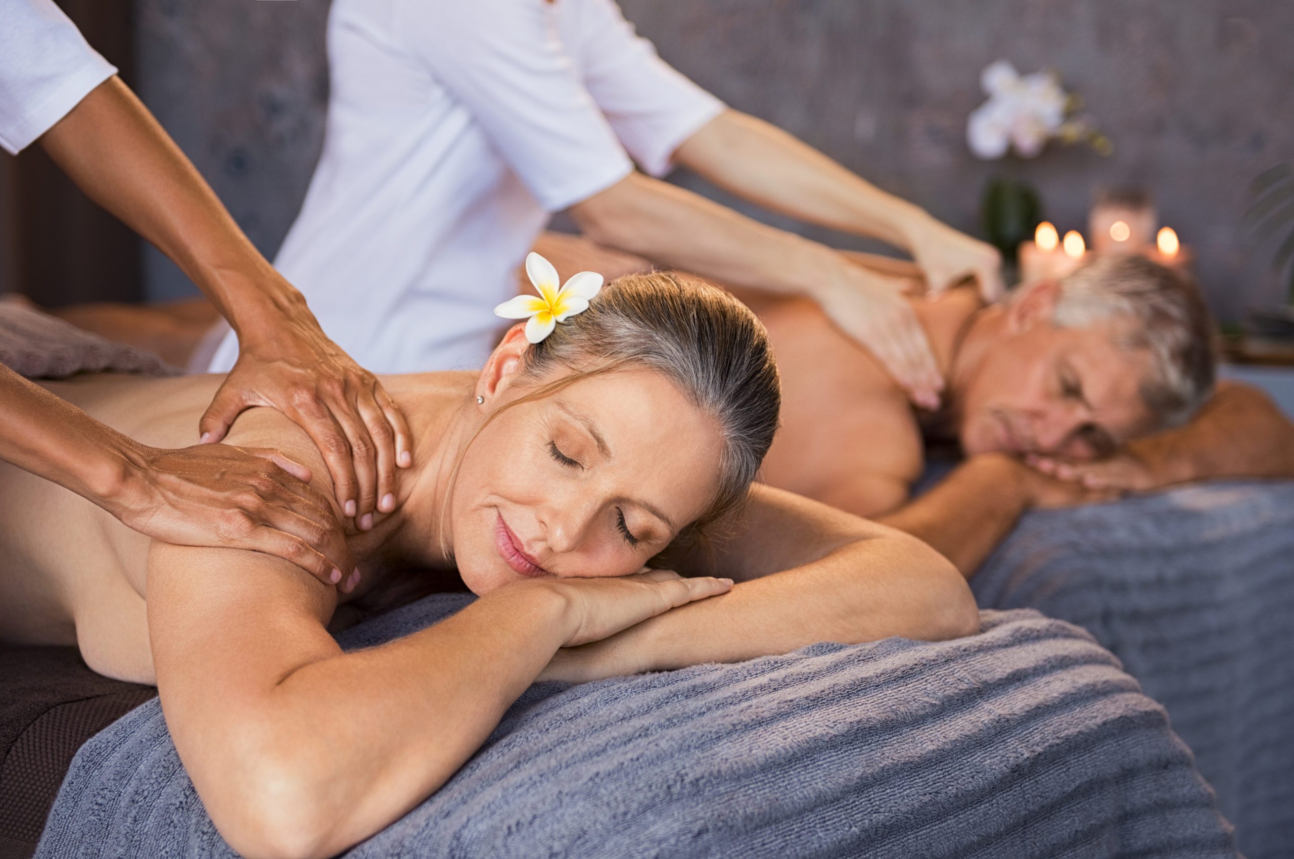 Mature couple having massage at spa Senior couple in spa salon getting massage. Relaxed senior couple enjoying body treatment in a wellness center. Retired man and woman receiving a back massage from masseur in a spa salon.