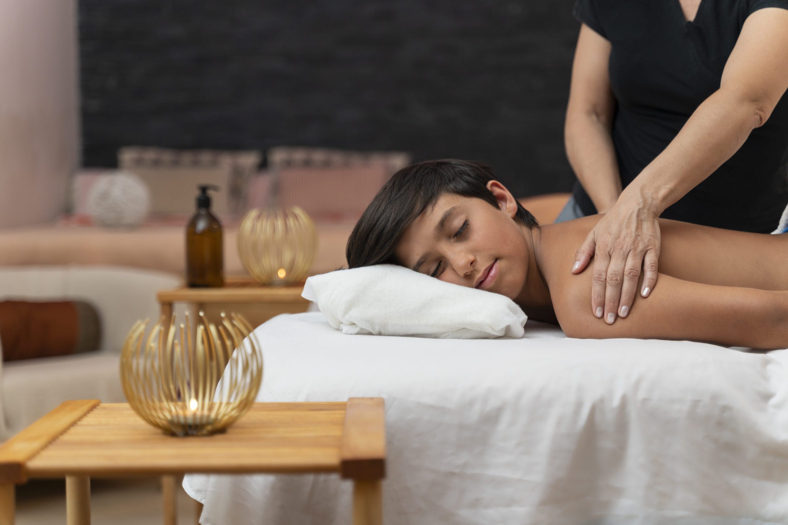 Child having a massage in a spa with his mother Portrait of kid having a massage in a spa with his mother